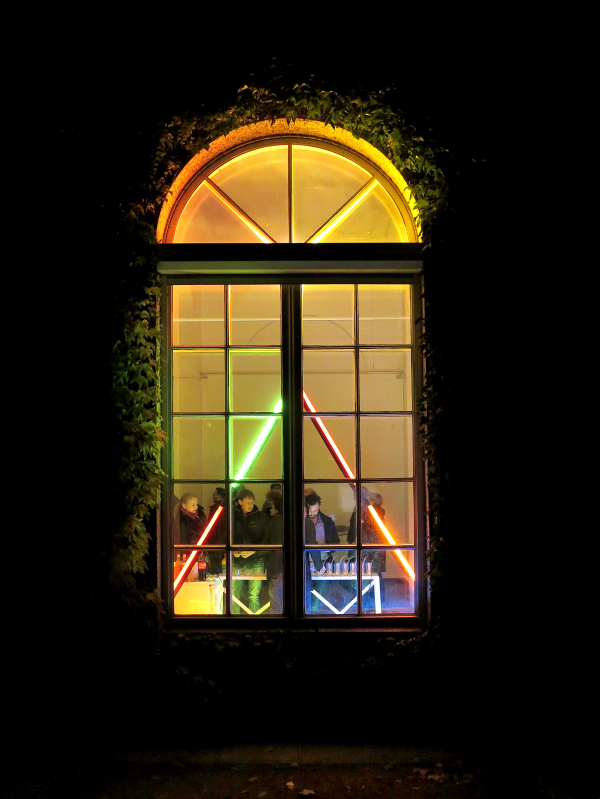 Farbig beleuchtetes Arkadenfenster der Galerie von außen bei einem Lichtevent im Beiptorgramm zur Ausstellung