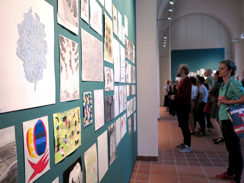 Nahansicht der Galeriewand mit diversen Zeichnungen während der Ausstellungseröffnung.