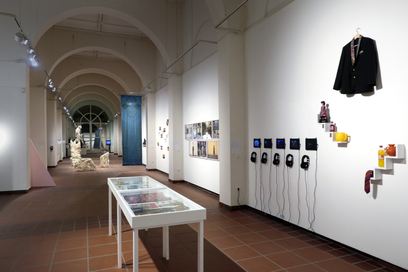 Blick in den Ausstellungsraum. Im Fordergrund ist die Colección Poyón von Ángel und Fernando Poyón zu sehen, die aus Objekten in Vitrinen und an der Wand besteht.