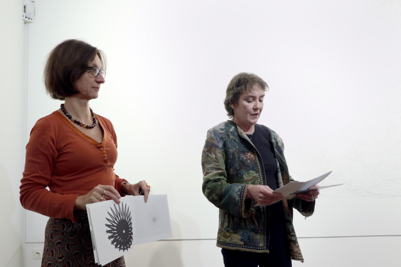 Rechts ist Frau Dorothee Bienert zu sehen, welche eine Abbildung aus dem Katalog von Kati Gausman zeigt. Links neben ihr Dr. Helen Adkins, bei ihrer Einführungsrede.