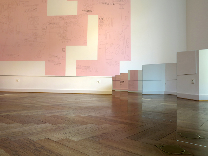 Unten am Boden ist Sinta Werners Installation aus quadratischen Spiegeln zu sehen. Darin spiegelt sich das Fischgrätenmuster des Parketts, die Wände der Galerie und die Raumzeichnung Ursula Döbereinrs wieder.