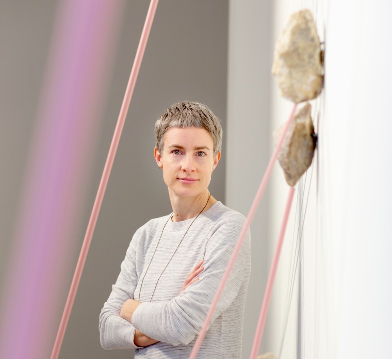 Die Künstlerin Catherine Evans steht neben ihrem Werk Standing Stone