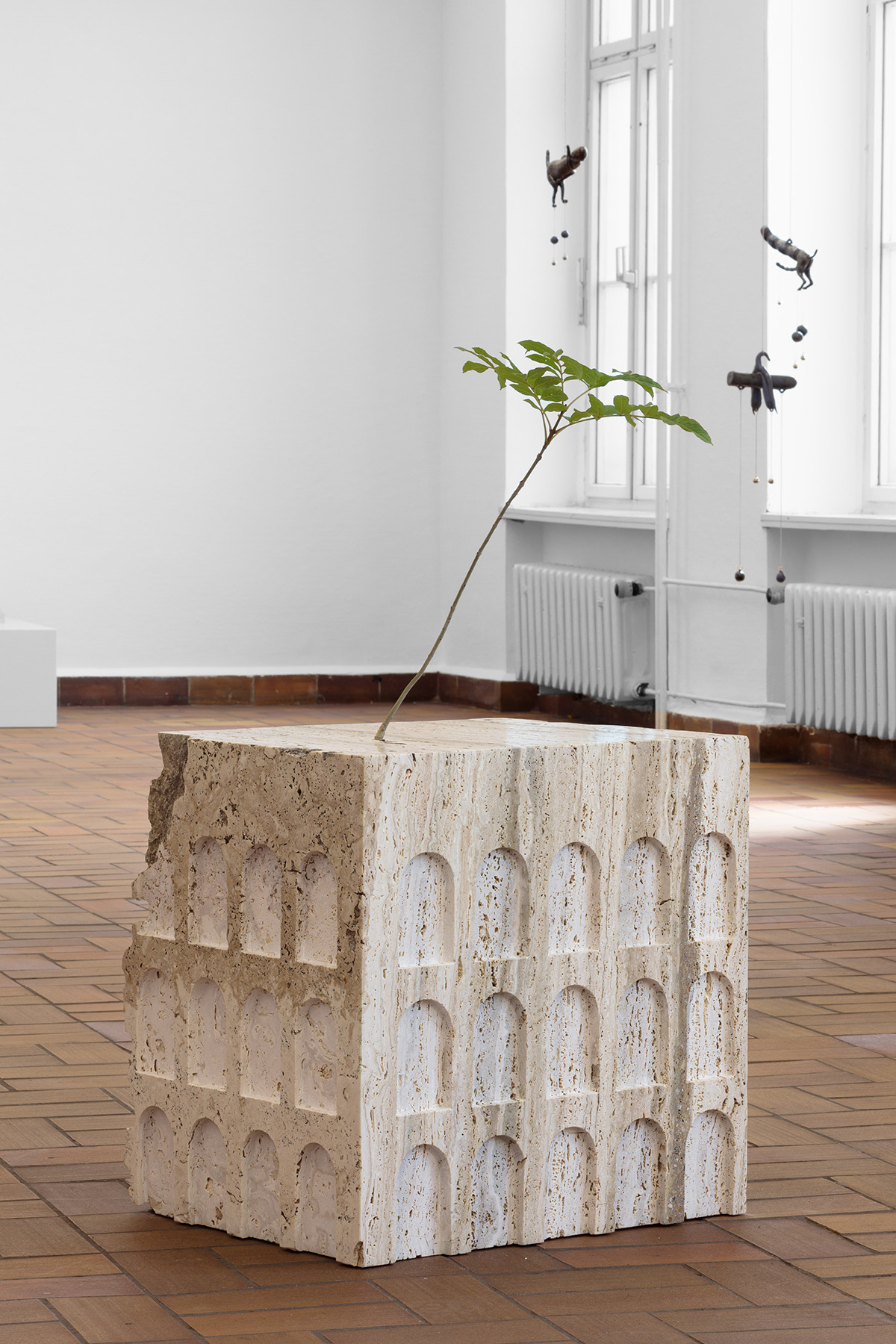 Lukas Liese · Problem (mit Dachbegrünung) · 2022 · Travertin · 60 x 55 x 60 cm · (Bildhintergrund: Zoë Claire Miller · Tintinnabuli Serie)