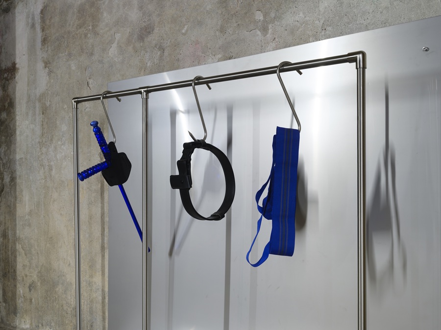 Constantin Hartenstein, Control Unit, 2026, Edelstahl, Glas, Polizeigürtel, Polizeiholster, Magazintasche, Jockstrap, Gummi. Ausstellungsansicht Galerie Parterre 2026.