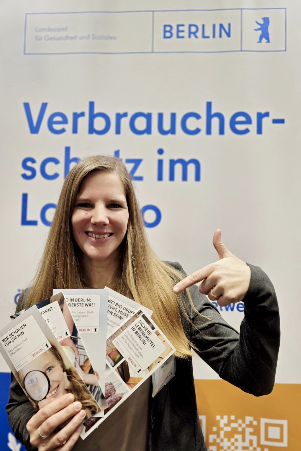 Eine Mitarbeiterin hält Lageso-Flyer in der Hand