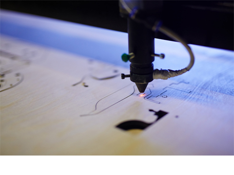 Die Spitze eines Lasercutter gleitet über eine Platte