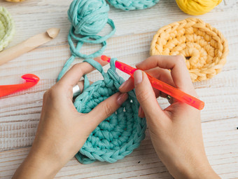 Blick auf Hände, die gerade etwas häkeln