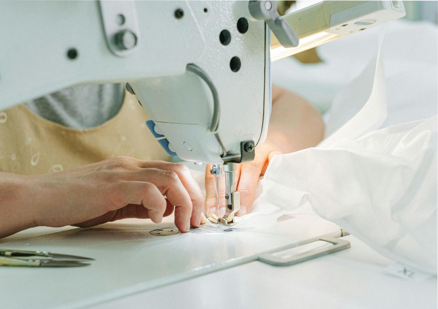 Eine Person näht Stoff an einer Nähmaschine