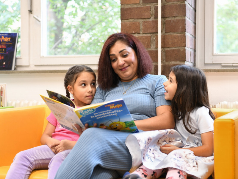 eine Frau liest Kindern vor