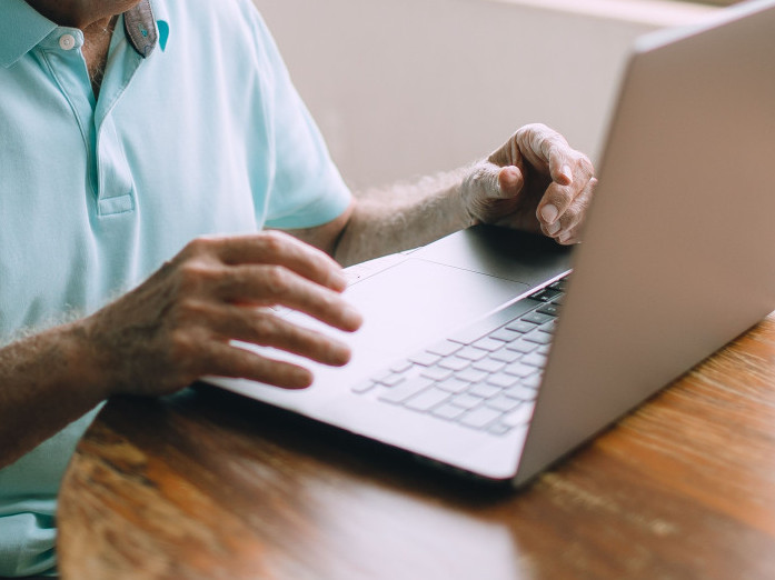 Bild von Person an Laptop.