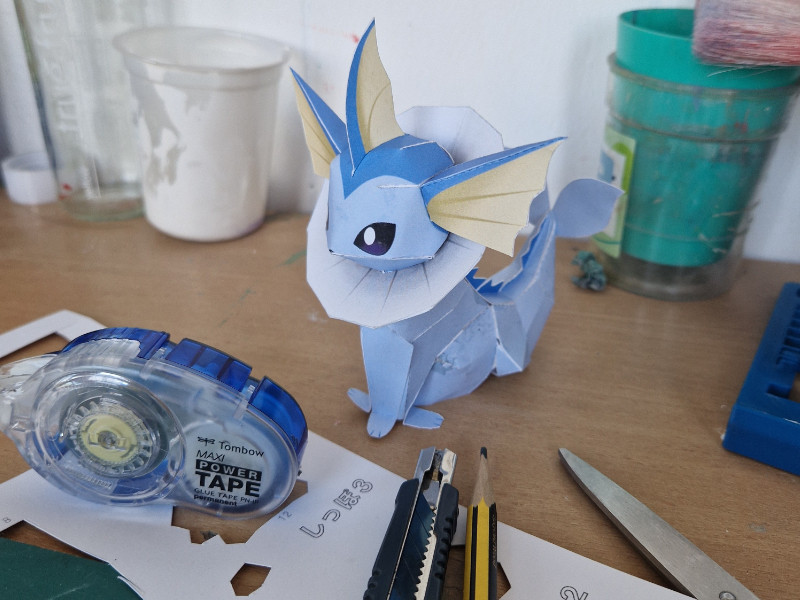 verschiedene Dinge liegen auf einem Tisch neben einem kleinen blauen Papierdrachen