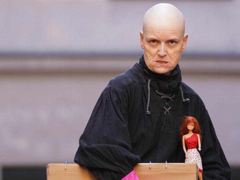 Die Schauspielerin Bridge Markland mit einer Box und einer Barbie Puppe