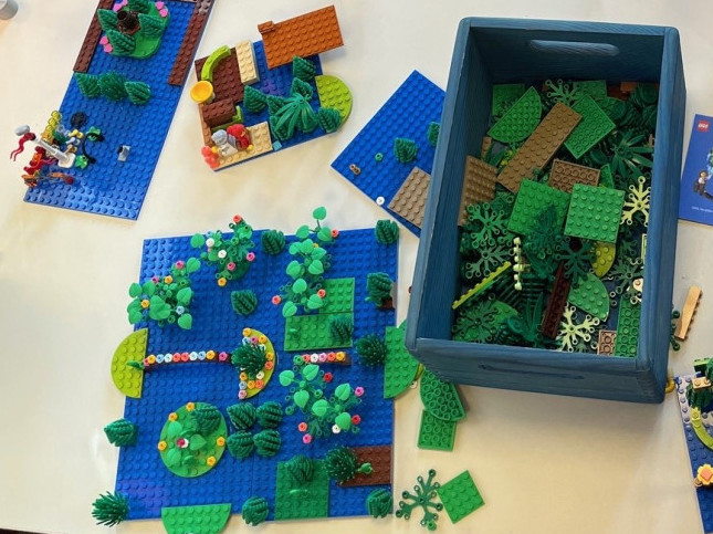 Legosteine in Kiste und von Kindern gebaute Ideen zu Build the Change