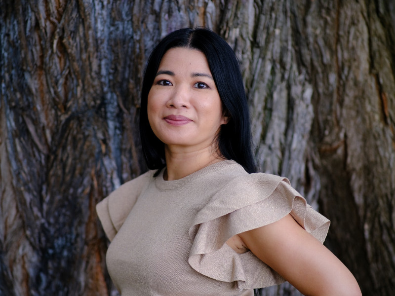 die Autorin Thị Thanh Thảo Trần vor einem Baum stehend