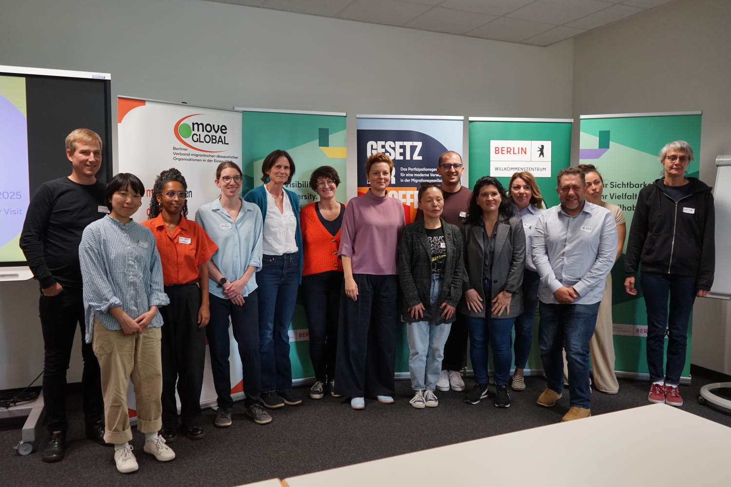 Gruppe von Menschen vor den bannern der Beauftragten für Partizipation, Integration und Migration