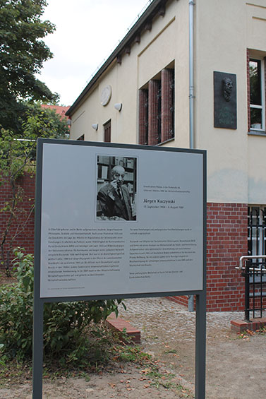 Informationstafel für Jürgen Kuczynski, im Hintergrund die von Harald Kretzschmar gestaltete Gedenkplatte