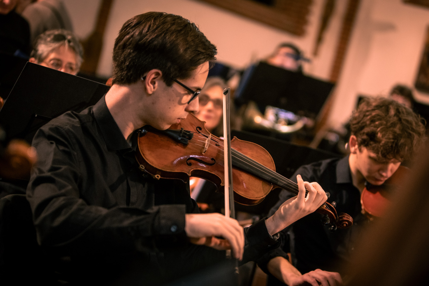 Junger Mann spielt Violine im Orchester