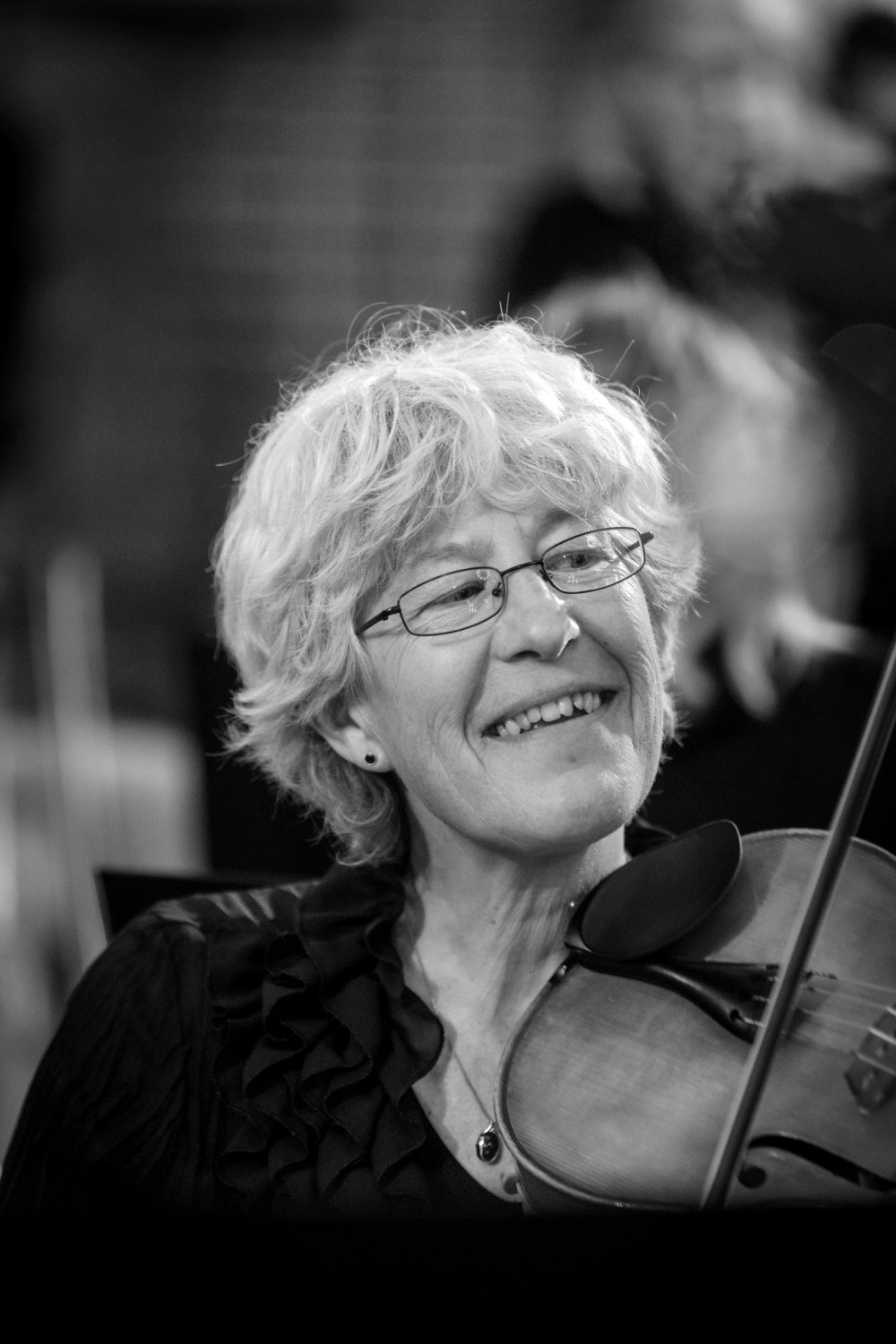 Violinistin lächelt beim Spielen.