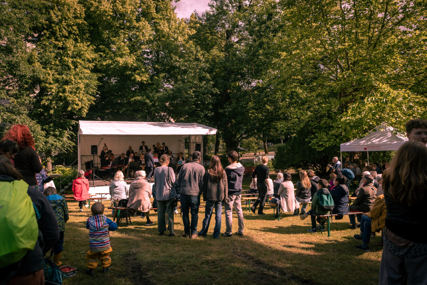 Publikum vor einer Bühne im Garten der Musikschule