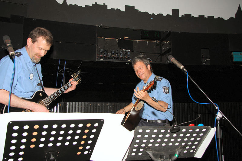 Polizisten mit Gitarre vor Notenständern