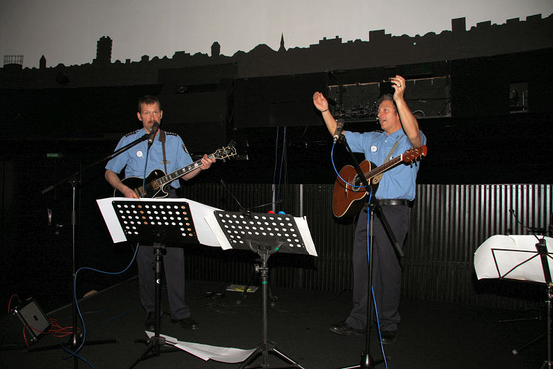 Polizisten bei der Aufführung mit Gitarren am singen