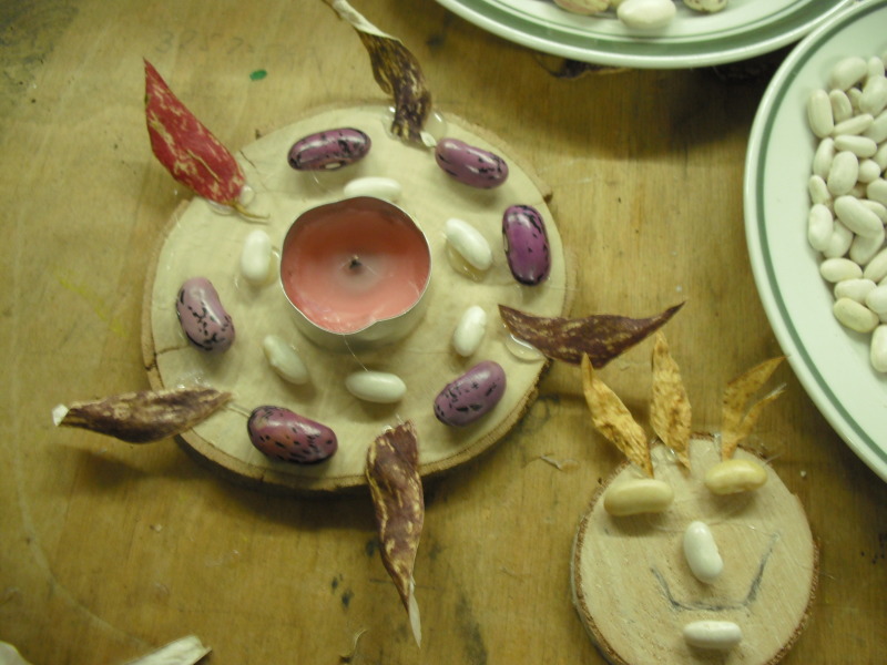 Bohnensamen auf Holzuntersetzer mit Teelicht