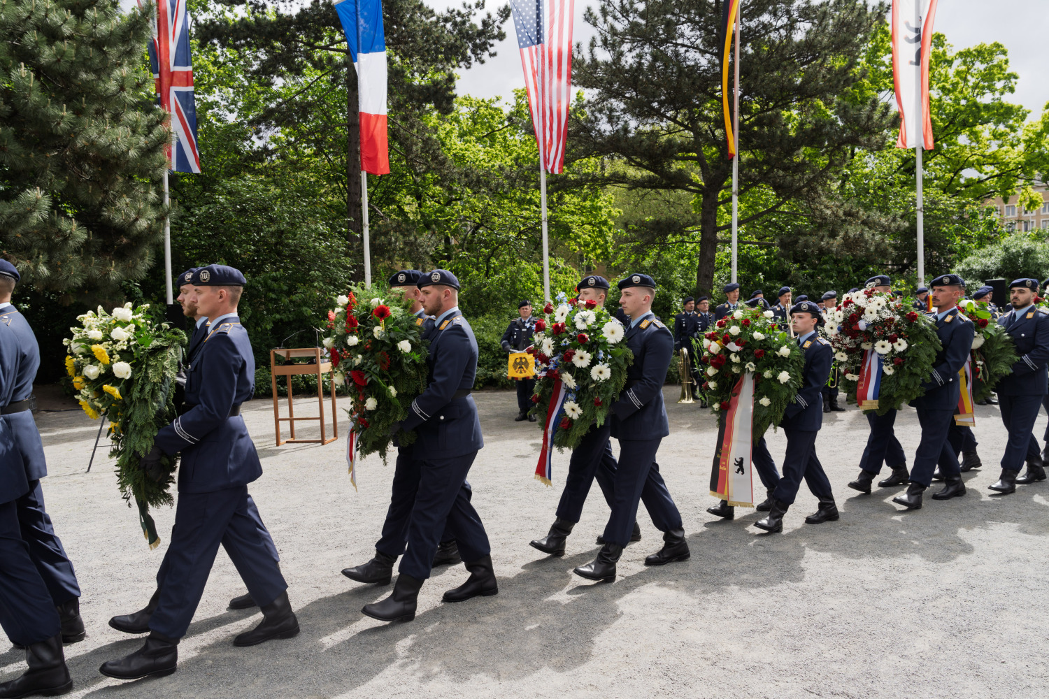 Ansicht Soldaten in Uniform tragen Kränze zum Luftbrückendenkmal