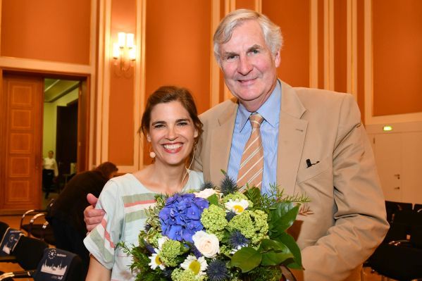 Die Moderatorin Judith Döker mit Dr. Klaus Herlitz vor der Bühne im Festsaal