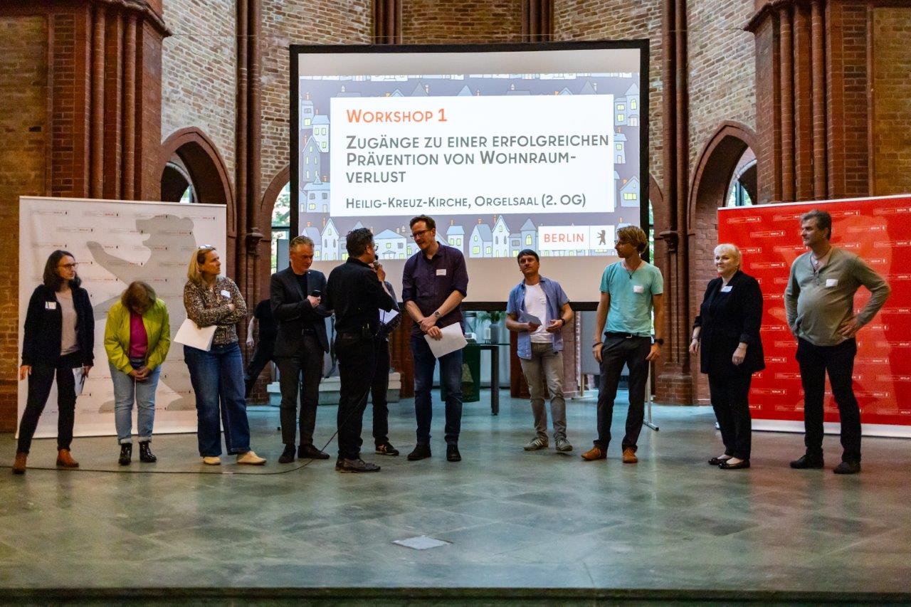 Workshop-Koordinator*innen stellen die Ergebnisse ihrer Workshops auf der Bühne vor.