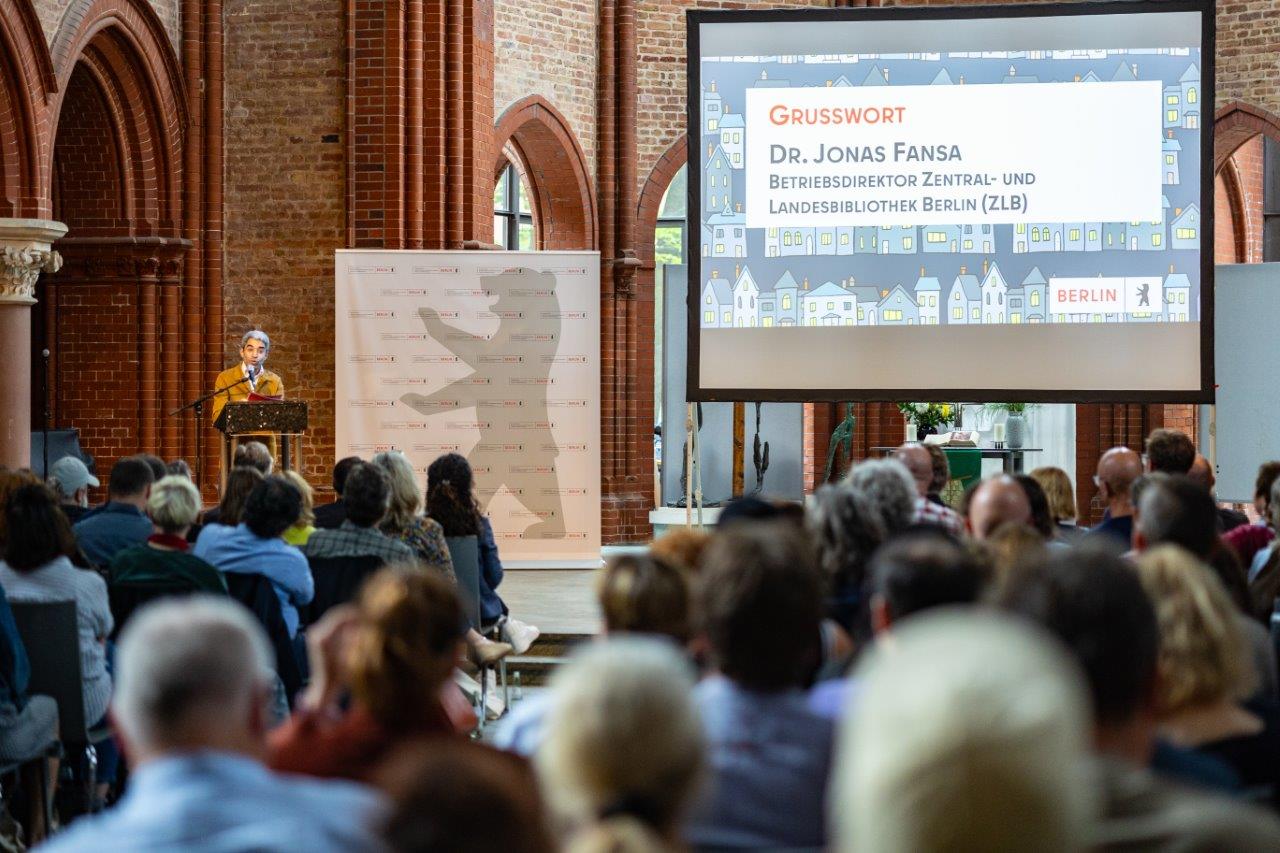 Dr. Jonas Fansa von der Zentral- und Landesbibliothek Berlin (ZLB) hält ein Grußwort.