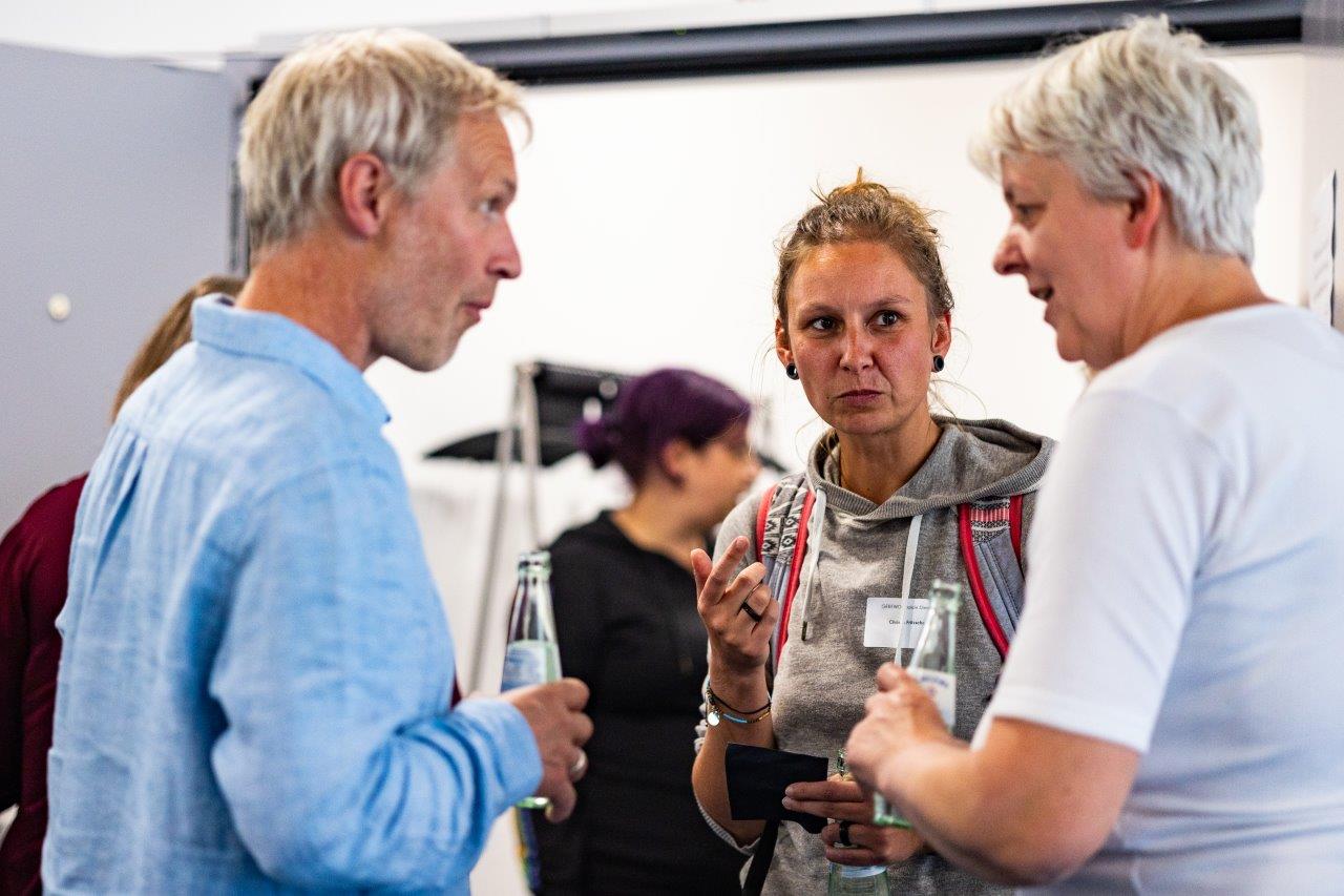 Konferenz-Teilnehmer*innen tauschen sich aus.