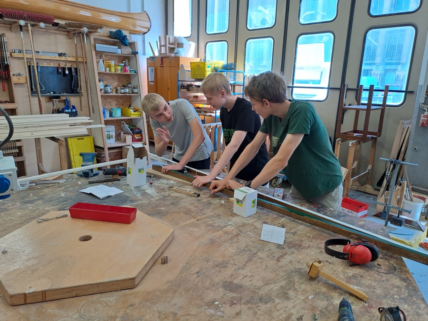 Drei Jugendliche in der Fliegerwerkstatt der social return Stiftung