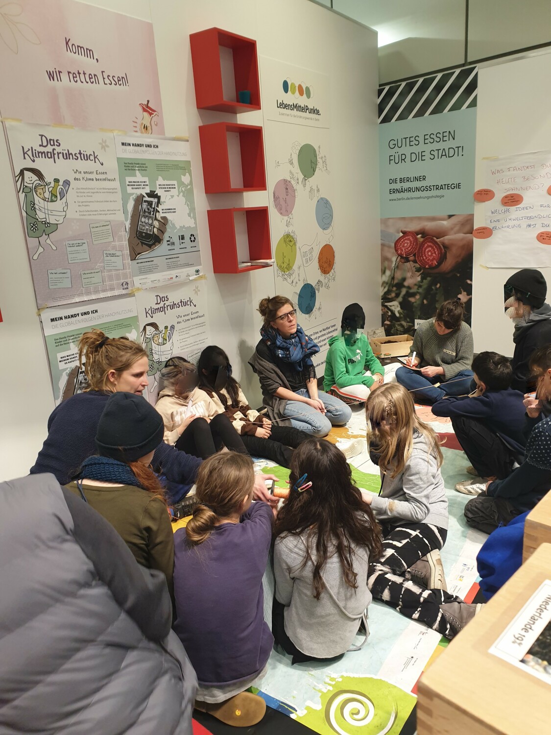 Kinder und Erwachsene sitzen zusammen in der Senatslounge für einen Workshop