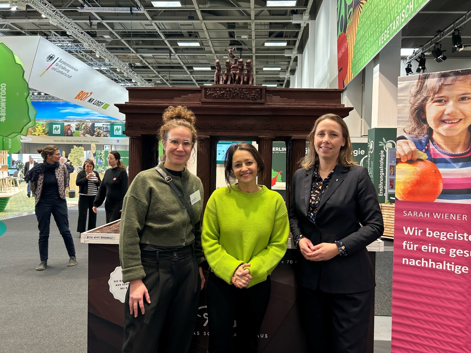 Senatorin Badenberg und Staatssekretärin Uleer und Frau Schermer vor dem Brandenburger Tor aus Schokolade