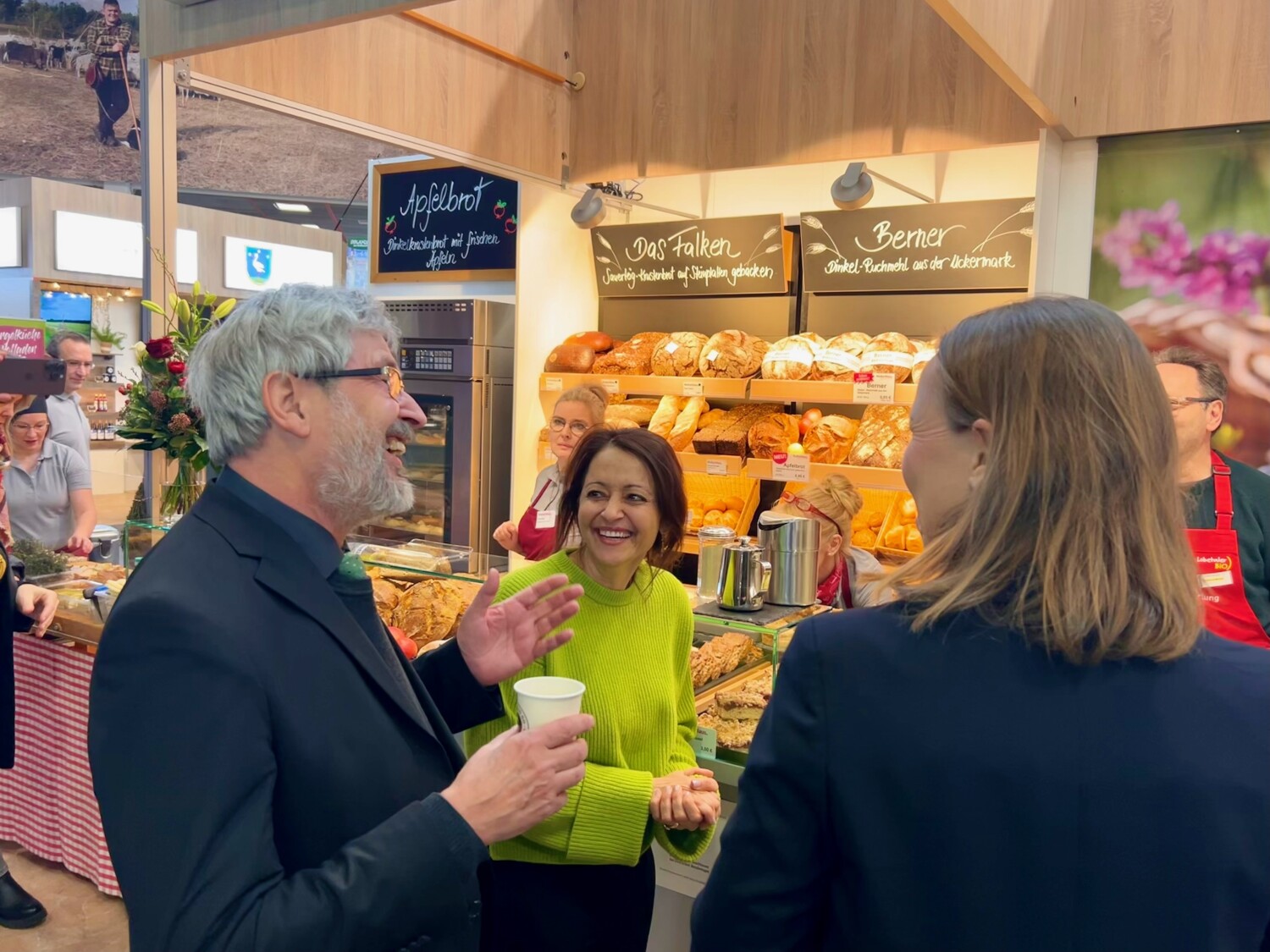 Senatorin Badenberg an einem Bäckereistand im Gespräch lachend