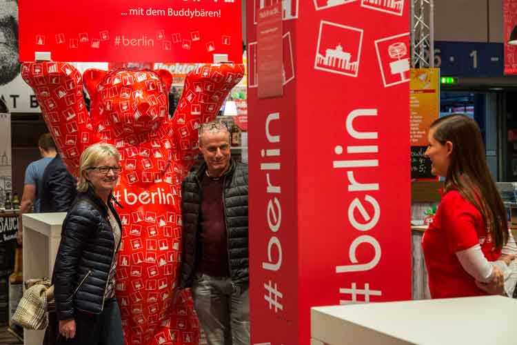 Ein Mann und eine Frau neben dem Buddybären