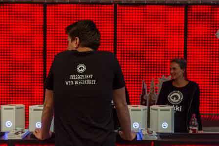 Ein Mann steht mit dem Rücken zur Kamera, sein T-Shirt hat den Aufdruck Heissgeliebt weil Eisgekühlt