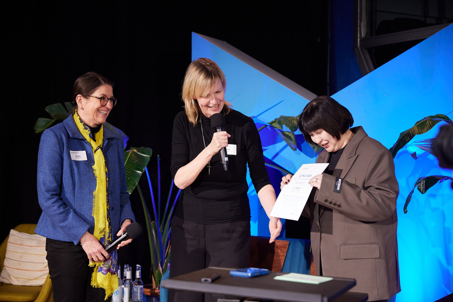 Verleihung einer Urkunde auf der Bühne der Female Capital Pitch Night
