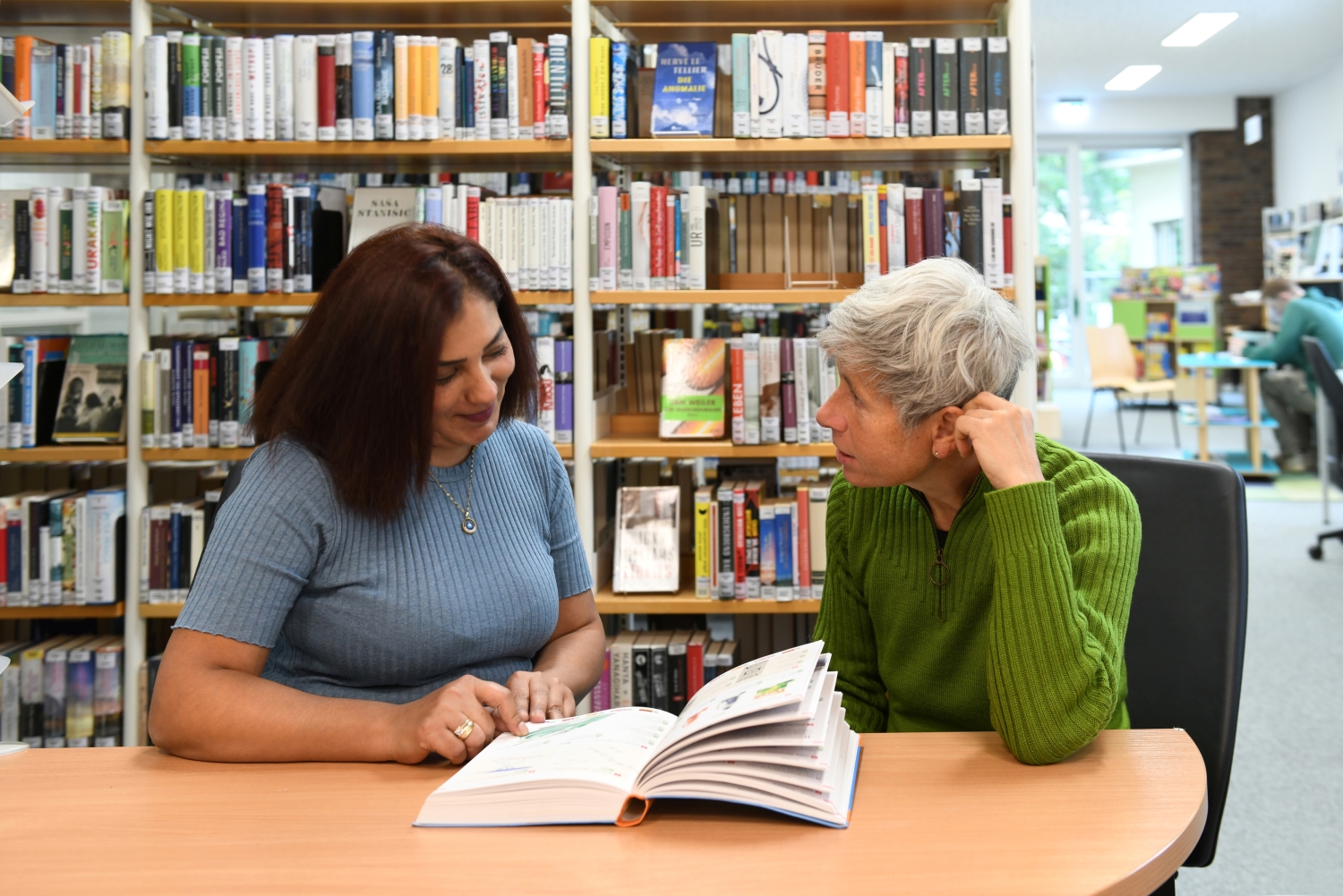 Zwei Frauen sitzen in der Kurt-Tucholsky-Bibliothek und lesen
