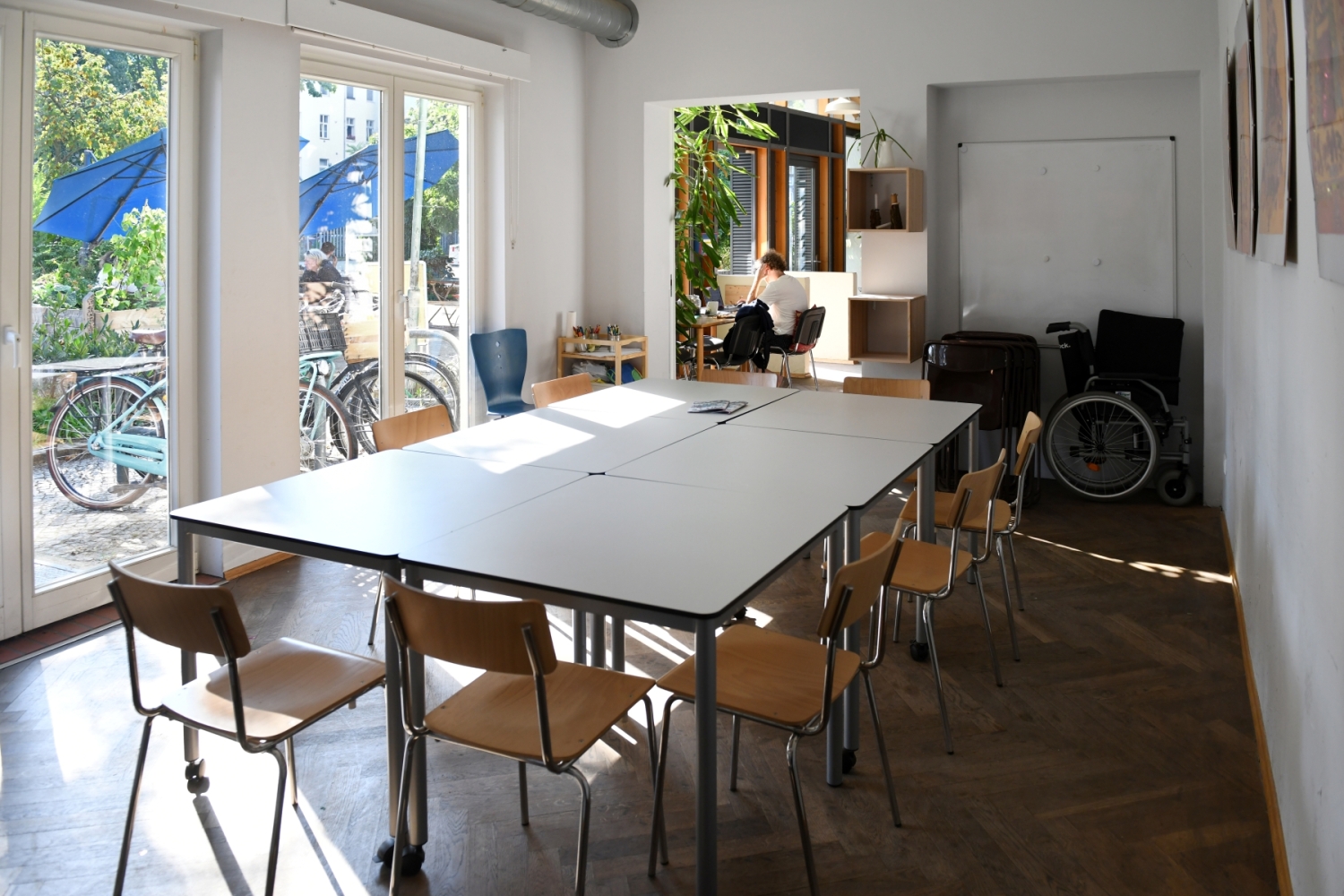 Der lichtdurchflutete Workshopraum der Bibliothek Tiergarten-Süd mit Tischen und Stühlen