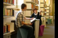 Foto in der Bibliothek mit einer Bibliothekarin und einem auszubildenden jungen Mann