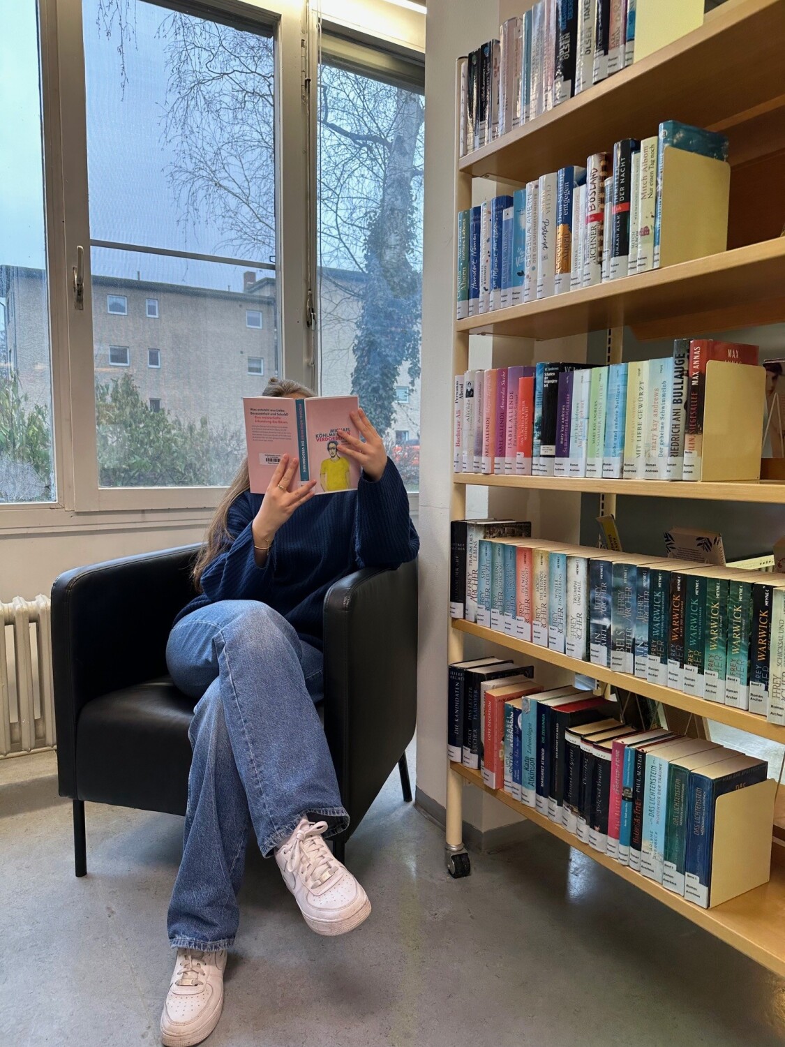 Eine Leserin liest ein Buch im Romanbereich