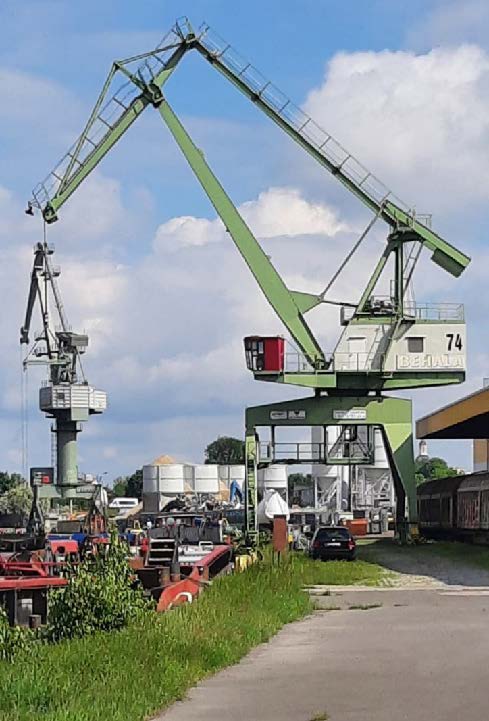 Nahaufnahme des Hafenkrans auf dem Unterhafen, blauer Himmel und Gras.