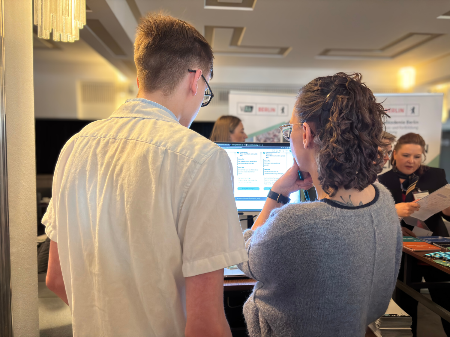 Zwei Personen tauschen sich über ein E-Learning am Computer aus.