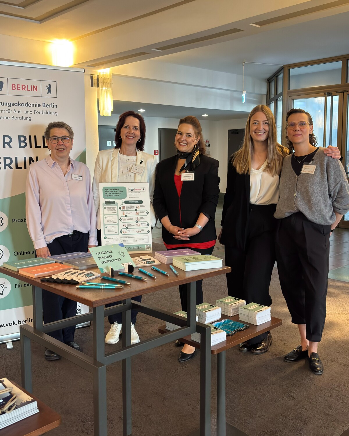 Das Team der Verwaltungsakademie am Thementisch mit Give Aways und Banner.