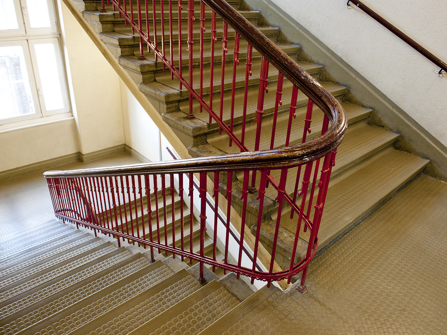 Treppenhaus mit rotem Treppengeländer