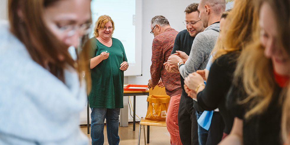 Teilnehmende und Kursleiterin bei einem Delegationsspiel