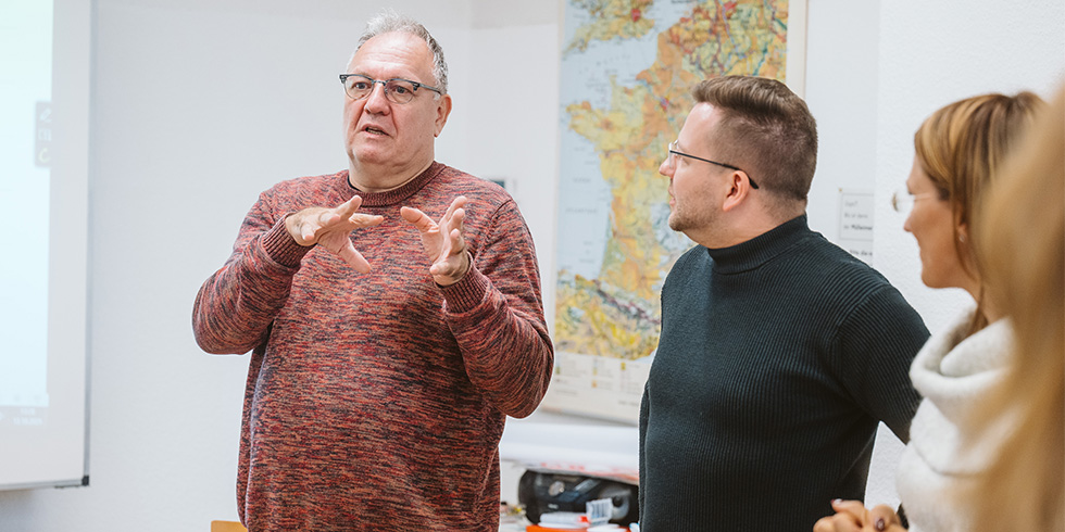 Teilnehmende diskutieren und gestikulieren stehend im Raum