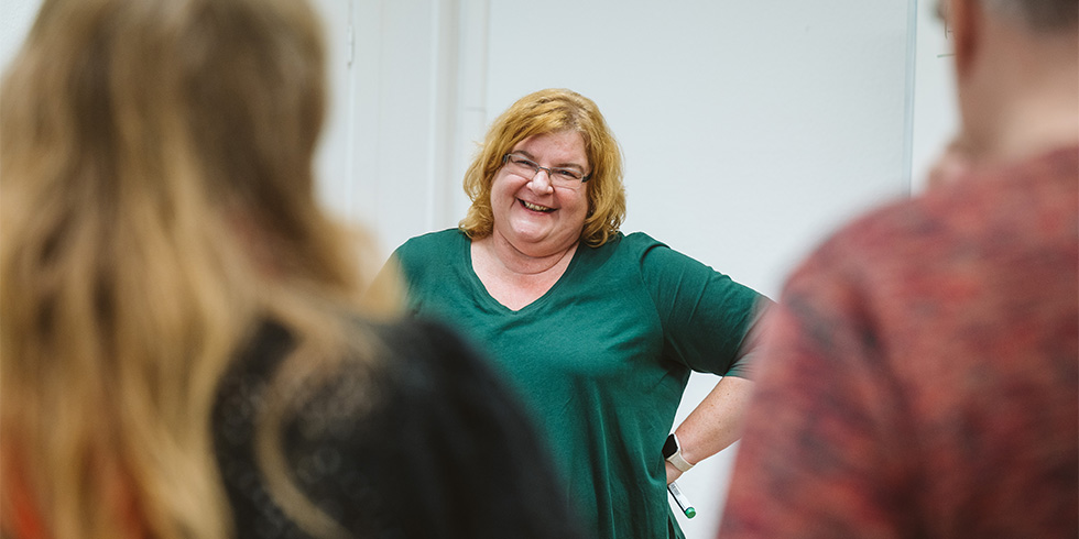 Kursleiterin Grebe im Gespräch mit zwei Teilnehmenden