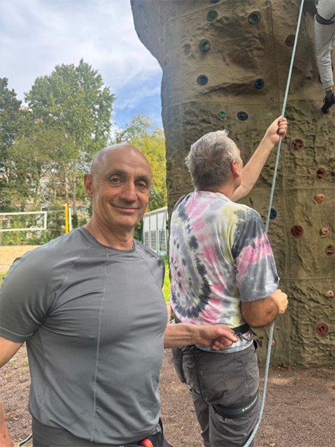 Alexander Danilov und Teilnehmer am Kletterfelsen in Sicherungsposition